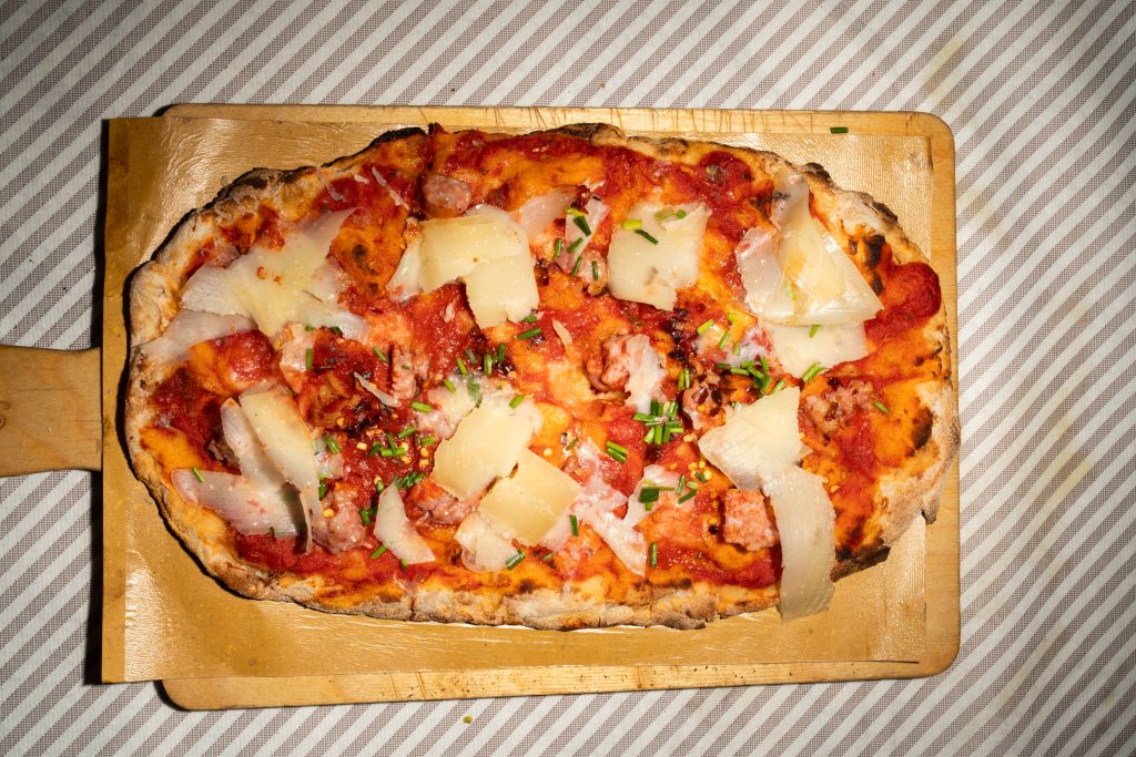 Pinsa rossa numero 2 con salsiccia, parmigiano e erba cipollina