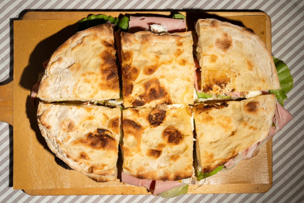 Pinsa ripiena numero 2 con mortadella, crema tartufata, insalata e bufala